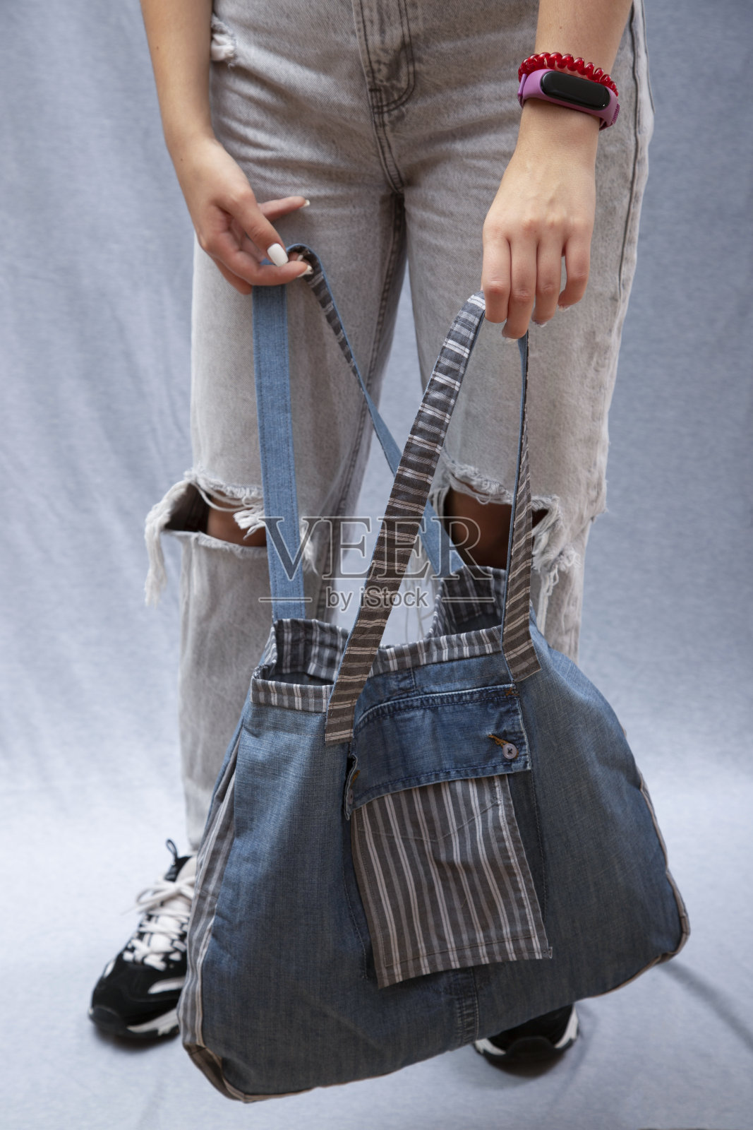 一个女孩手里拿着一个由天然织物制成的可重复使用的环保袋照片摄影图片