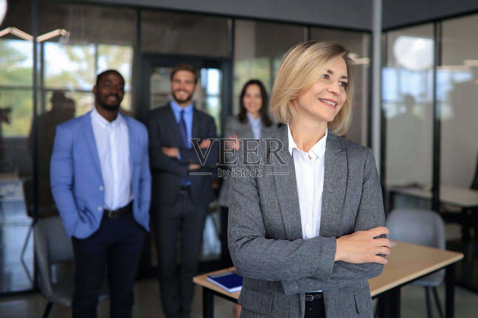 商务女性和她的员工，人们在现代明亮的室内办公室的背景。照片摄影图片