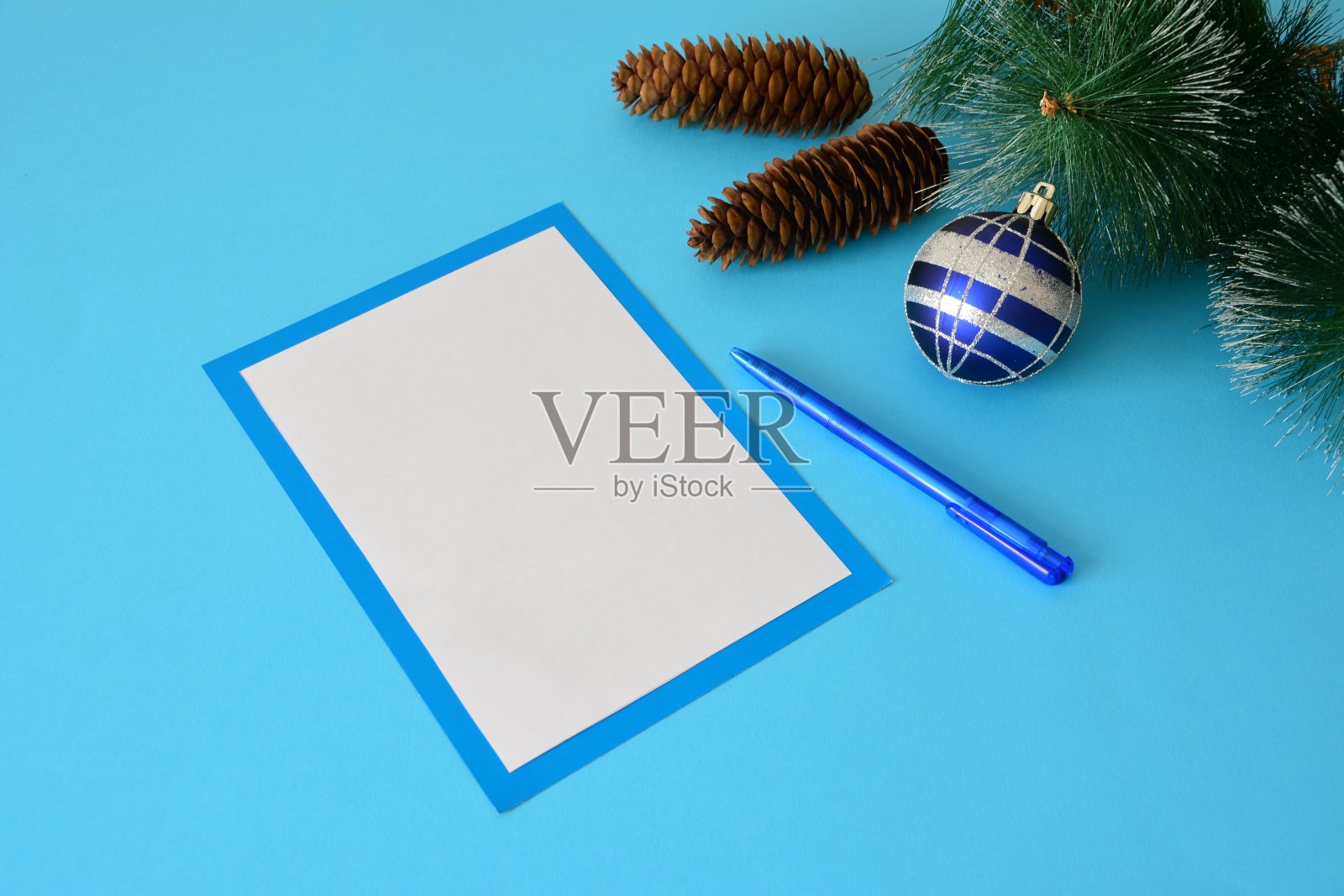 圣诞卡与笔，圣诞球和锥在蓝色背景照片摄影图片