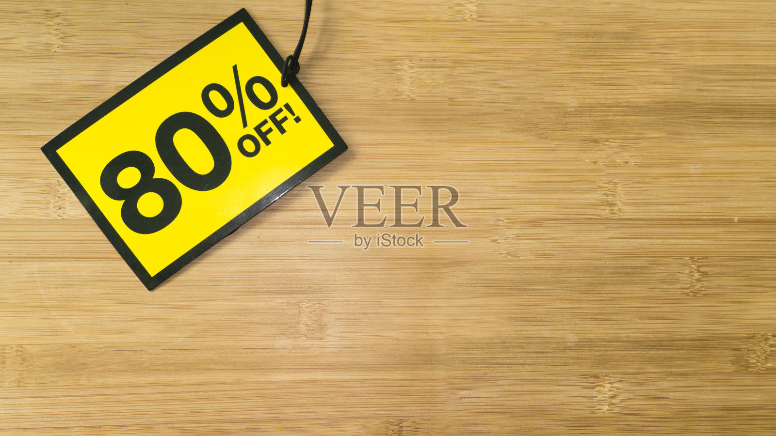 木制背景上的黄色销售标签。黑色星期五销售照片摄影图片