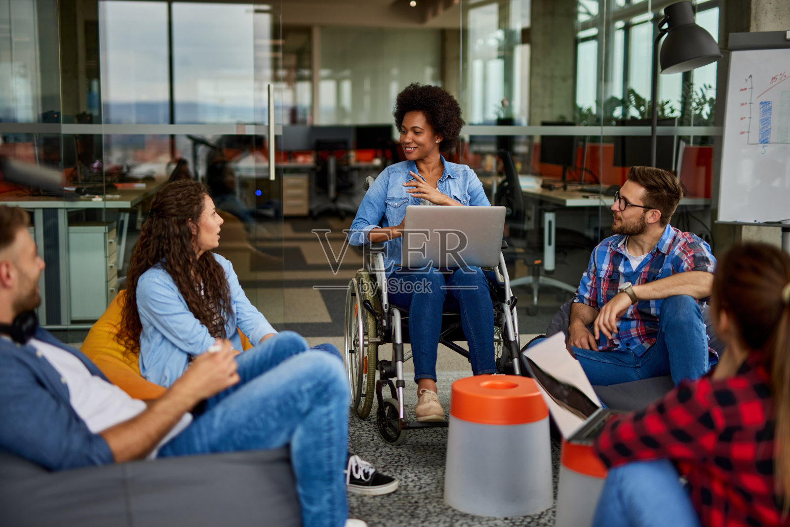 残疾女商人在办公室与同事讨论照片摄影图片