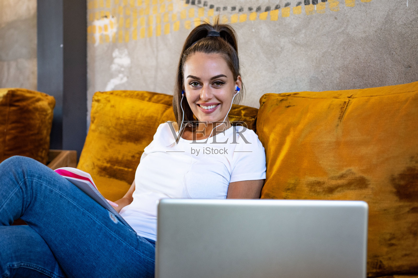 一名年轻女子在网上学习，她在笔记本上记笔记照片摄影图片