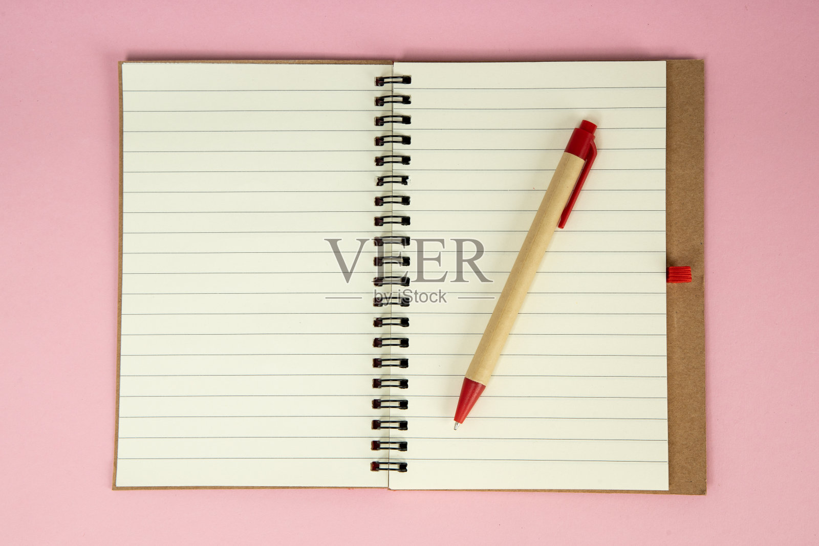 一套回收纸笔记本和笔。打开粉红色背景的日记本照片摄影图片