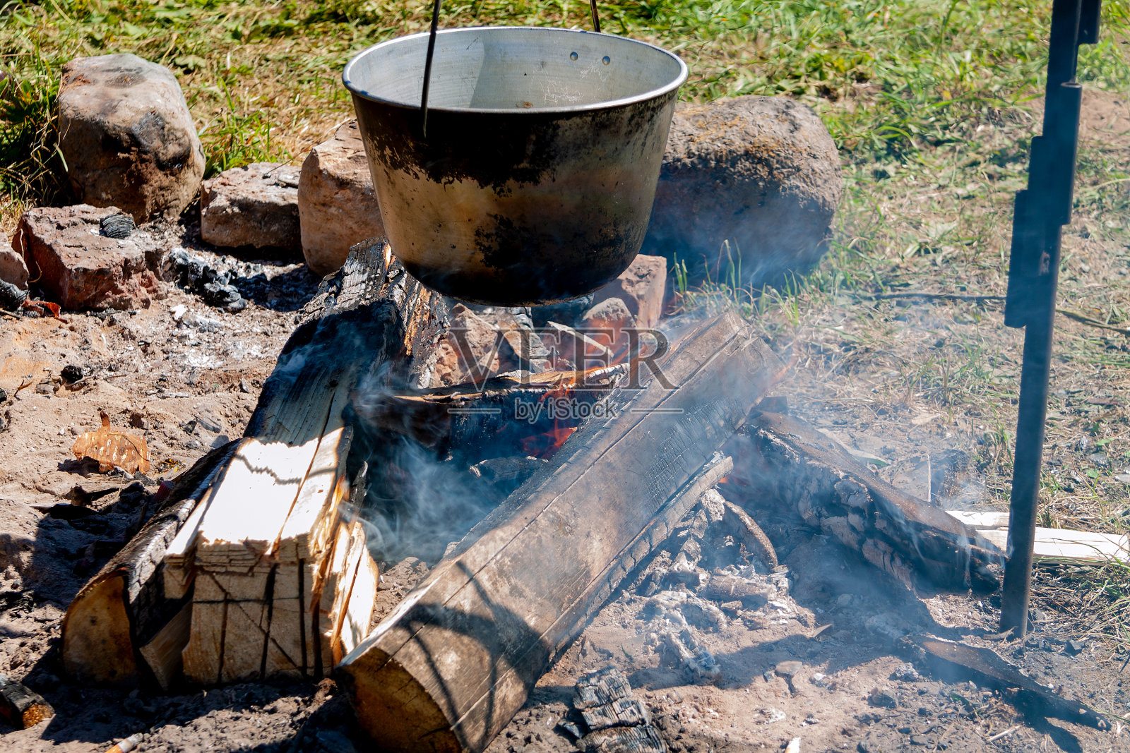 一只大锅悬在燃烧的火上照片摄影图片