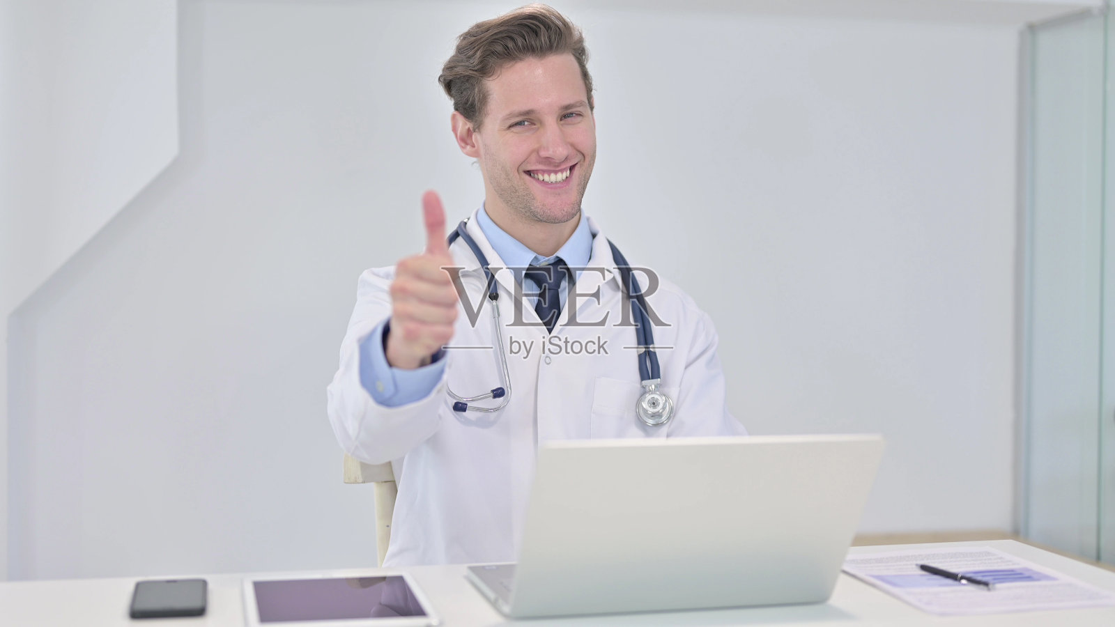 年轻医生在诊所里竖起大拇指照片摄影图片