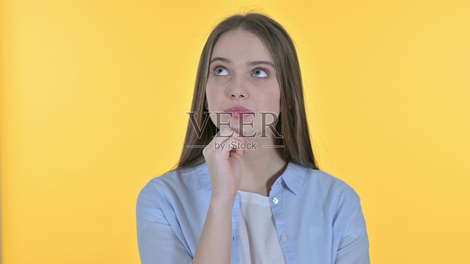 休闲年轻女子思考新想法，黄色背景照片摄影图片