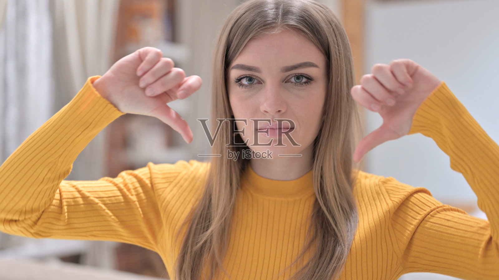 失望的年轻女子的肖像显示拇指向下照片摄影图片