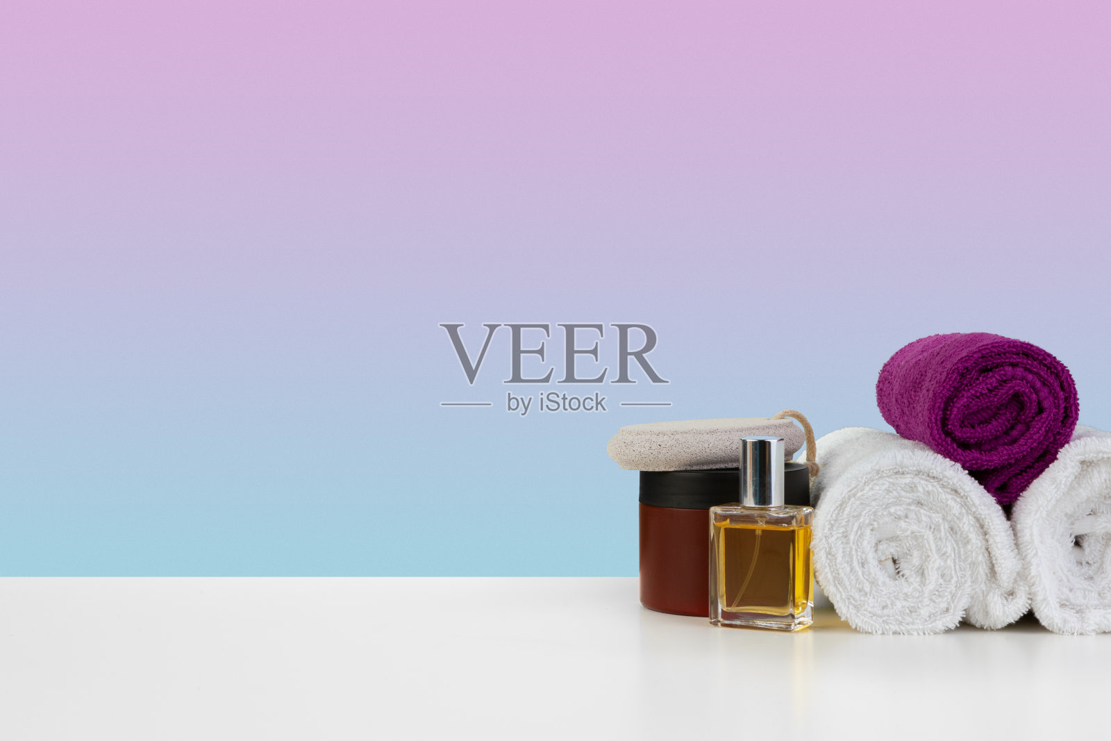 白色的桌子上有一堆毛巾和装着洗发水的瓶子照片摄影图片