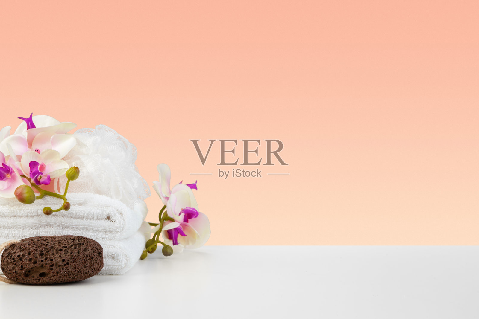 美丽的粉红色花朵和白色毛巾在粉红色的背景照片摄影图片