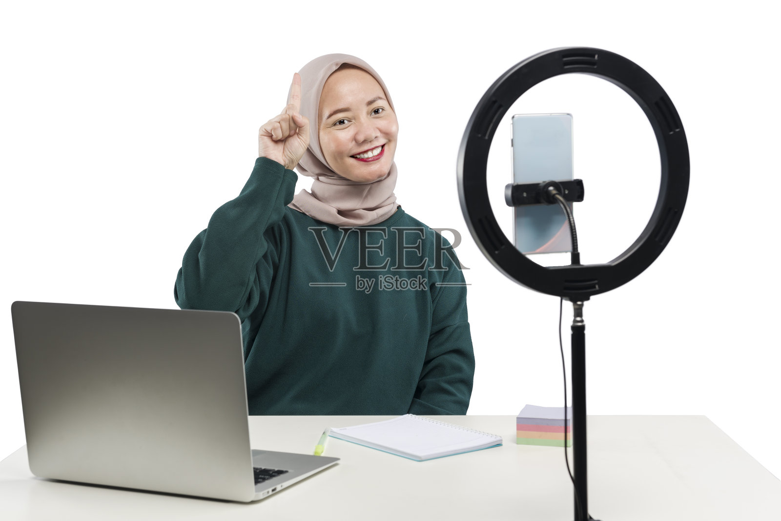 亚洲穆斯林妇女用笔记本电脑和带有照明设备的手机制作视频博客照片摄影图片