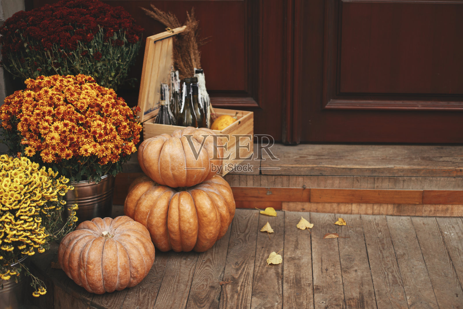 南瓜，秋天的花，木盒子和树叶在城市街道的人行道上，节日的乡村装饰。万圣节节日户外装饰。万圣节快乐。镇上的秋季市场。本空间照片摄影图片