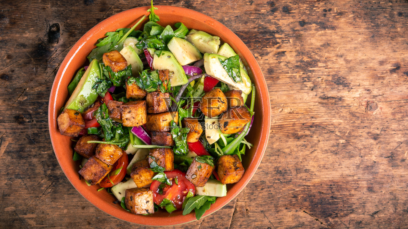素食蔬菜沙拉，芝麻菜，牛油果和炸豆腐，俯视图，复制空间-平衡的低碳水化合物饮食照片摄影图片