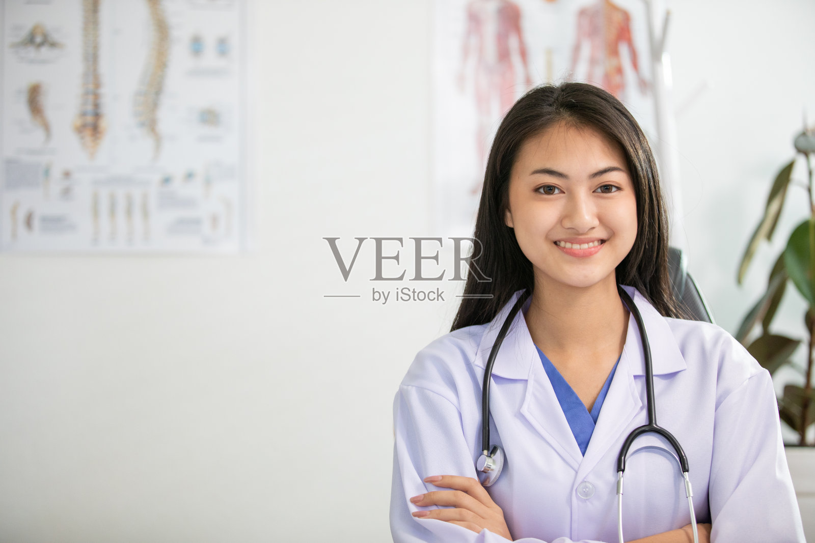 年轻的女医生微笑着在办公室工作照片摄影图片