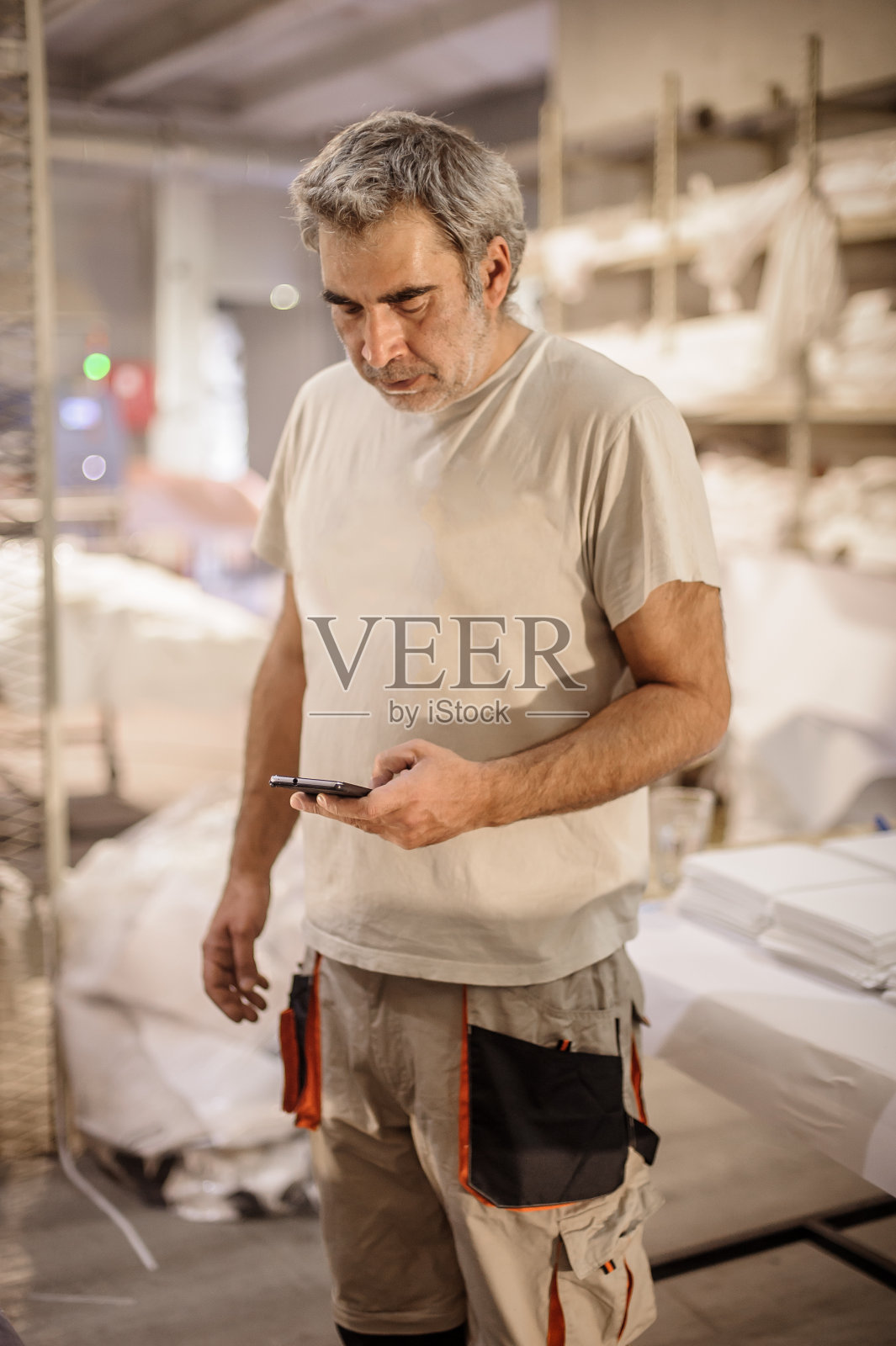 工人在车间休息和使用手机照片摄影图片