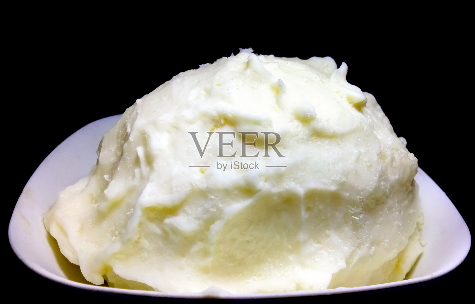 一碗黄油孤立在黑色背景上照片摄影图片