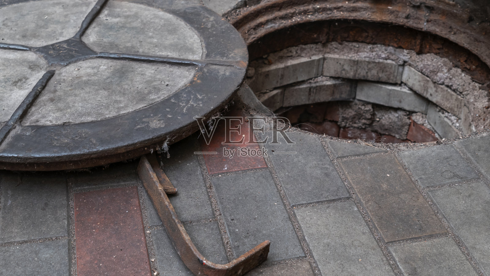 阻塞下水道排水。循环水。拆除装有旧铁制人孔的化粪池。照片摄影图片