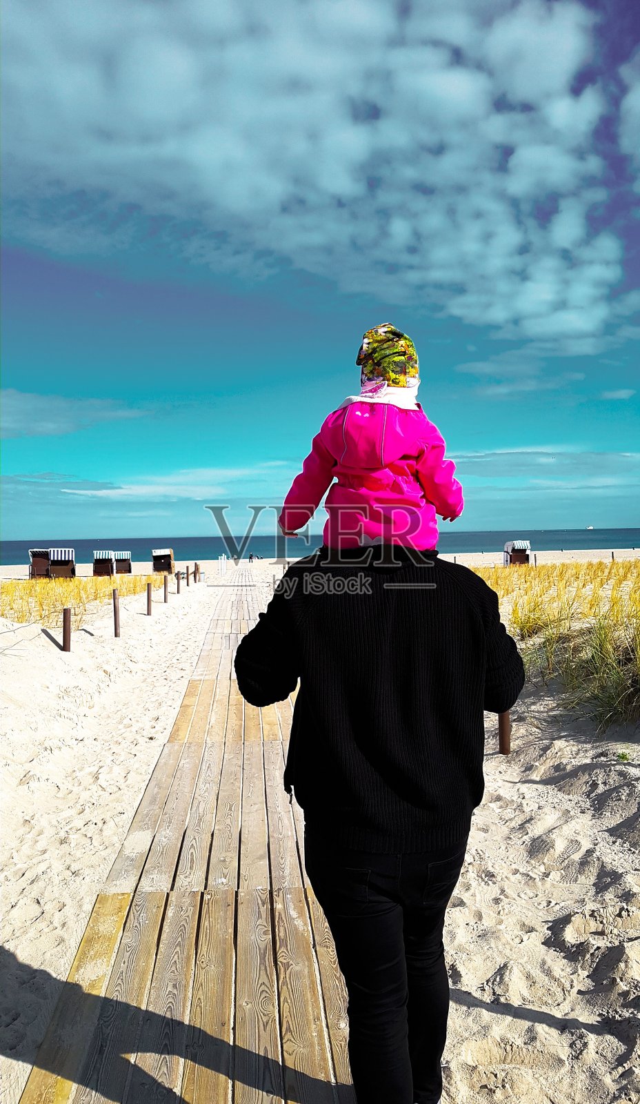 父亲和孩子到海边的防波堤上照片摄影图片