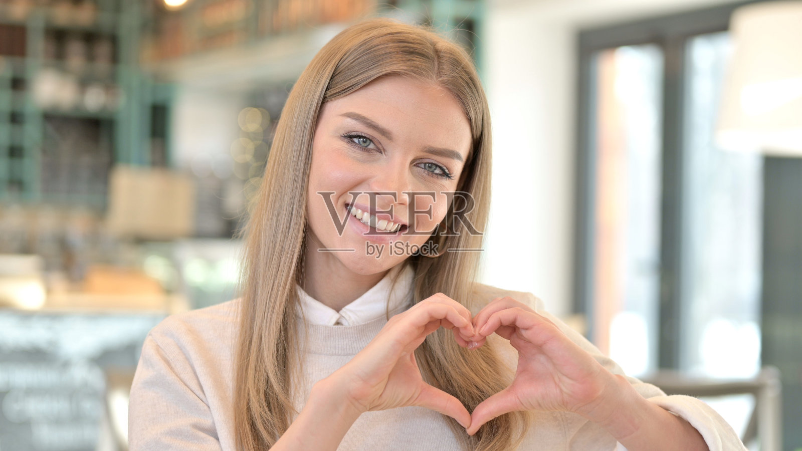 心形画像的年轻妇女，手势照片摄影图片