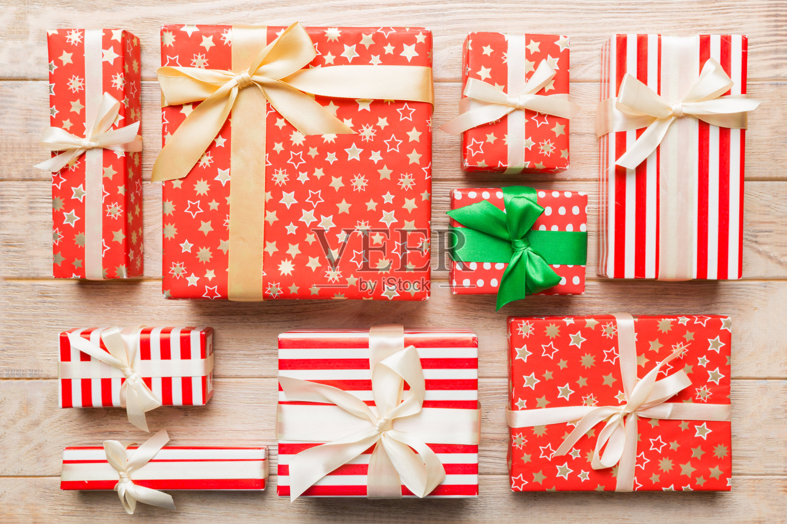 许多圣诞礼品盒用彩纸装饰在桌子上，俯视图关闭。许多人赠送新年礼物照片摄影图片