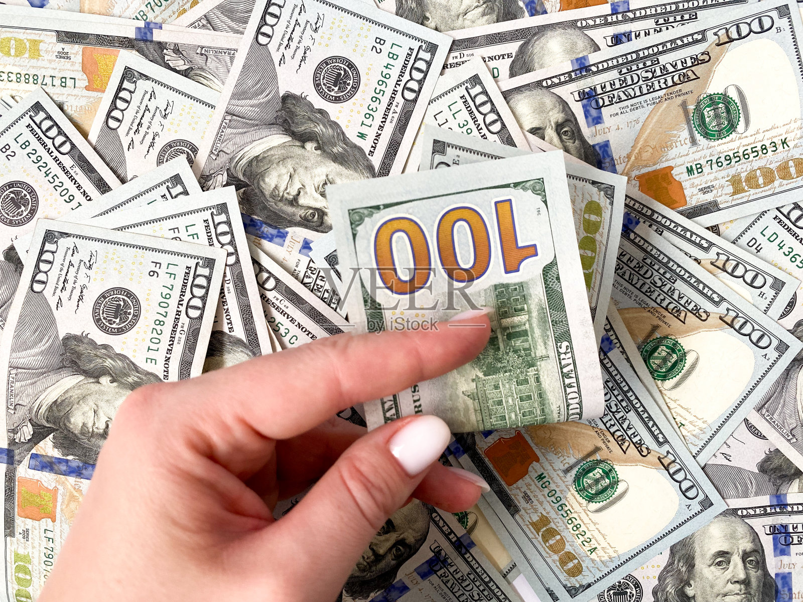 一个特写演员手里拿着一大笔钱。背景是由美元构成的。孤立的美元照片摄影图片