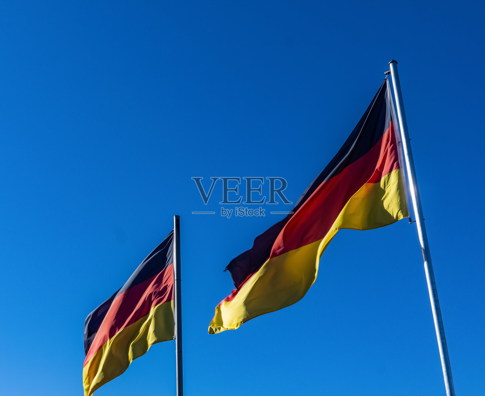 两面德国国旗迎风飘扬。照片摄影图片