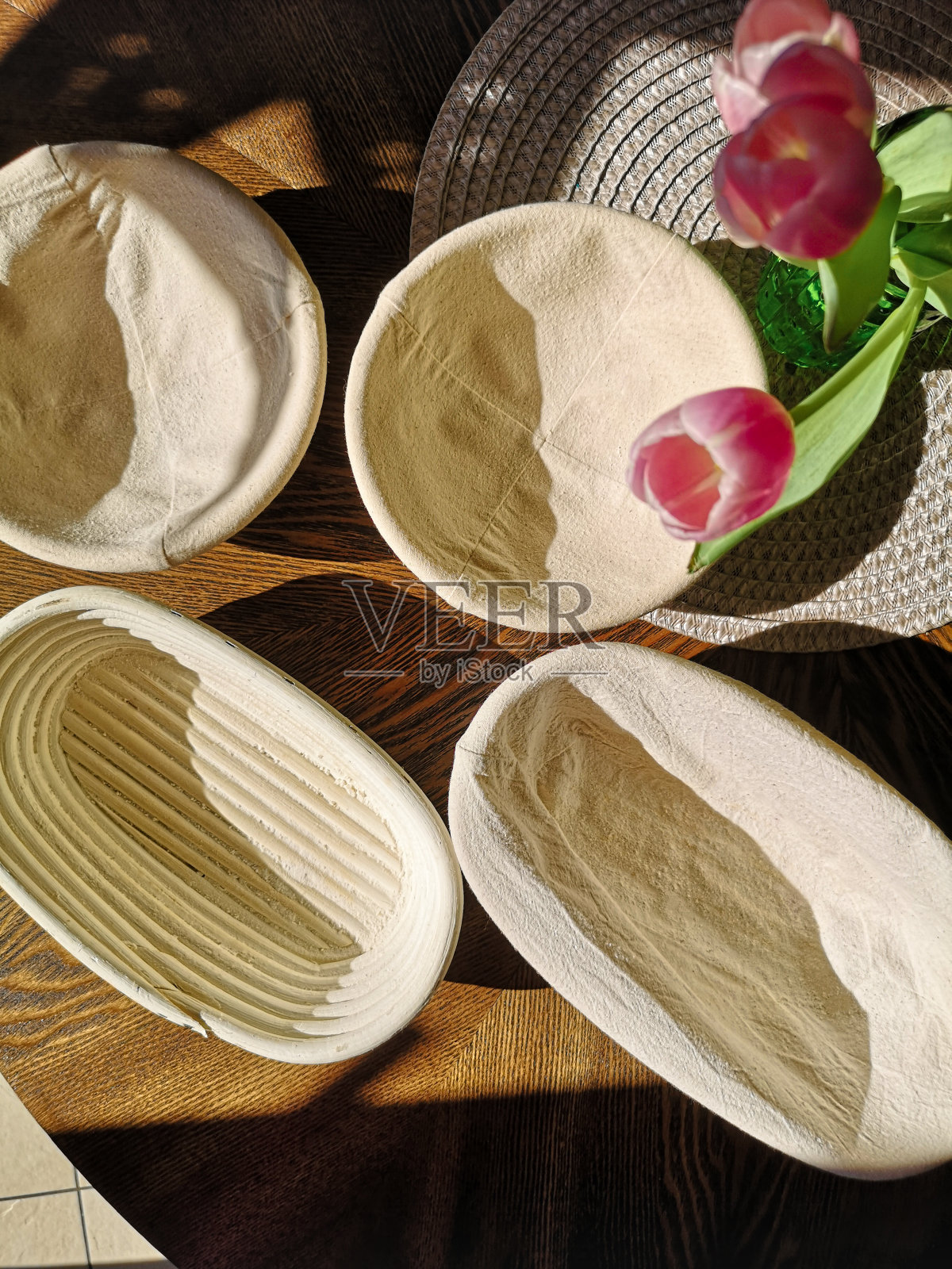 从上面看，桌子上放着装面团和鲜花的篮子照片摄影图片