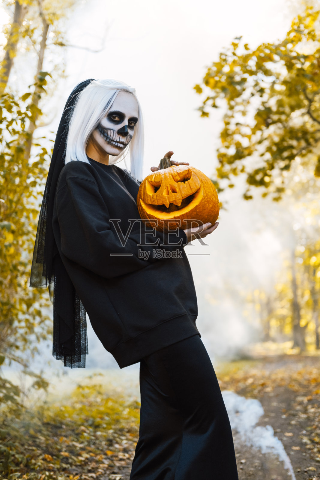 一个女人站在一团白烟中。照片摄影图片