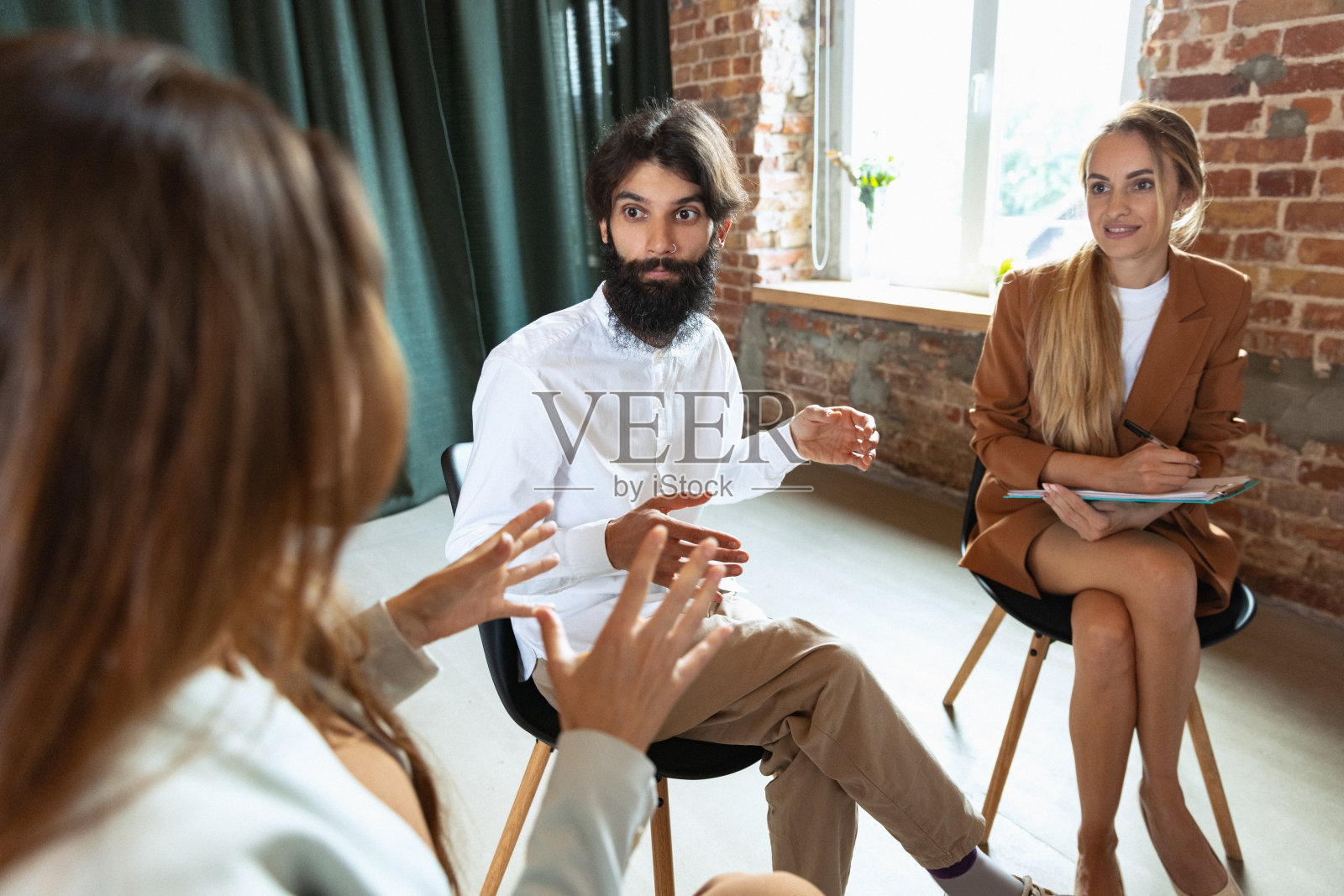 在心理支持小组中交谈沟通的年轻多元种族男女照片摄影图片