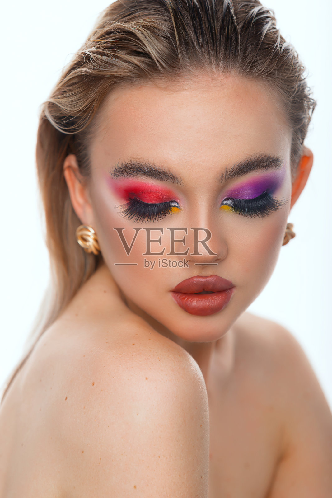 美丽女人的肖像。模特的专业化妆，蓝色的眼睛和丰满的嘴唇。红色的口红，彩色的烟熏妆。孤立在白色背景上。照片摄影图片