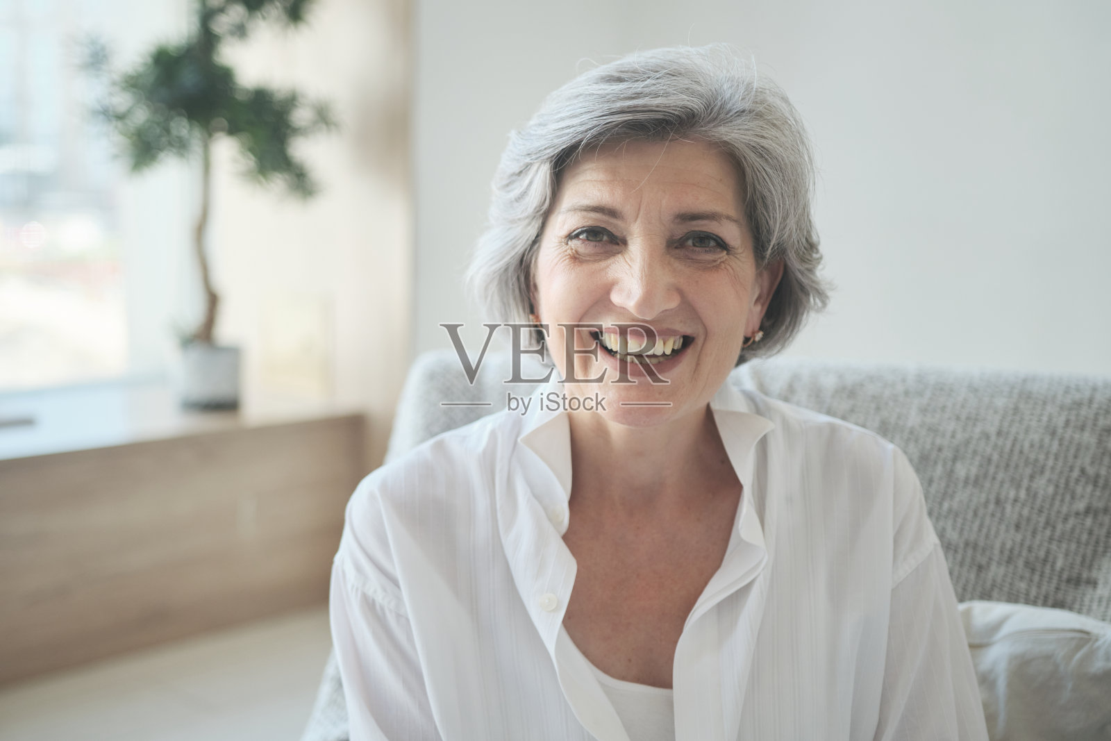 笑容满面的60多岁的中老年妇女正在使用视频电话会议照片摄影图片