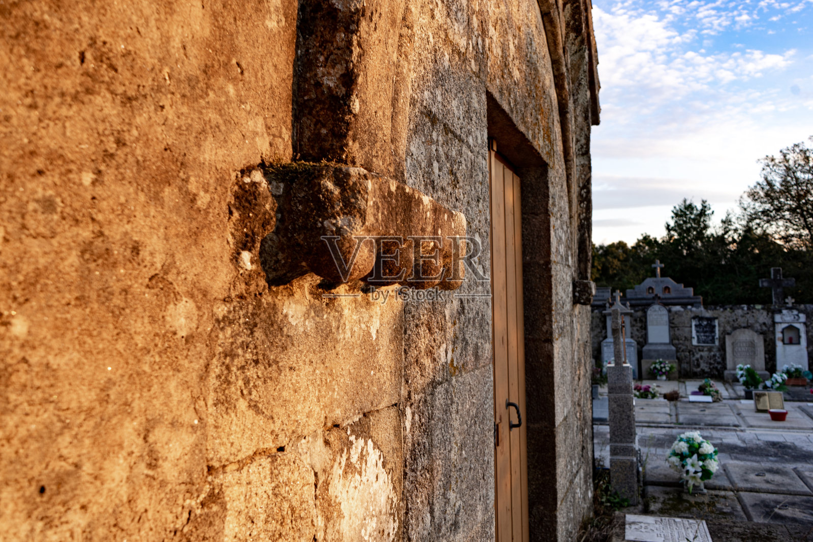 中世纪教堂的门，周围环绕着坟墓照片摄影图片