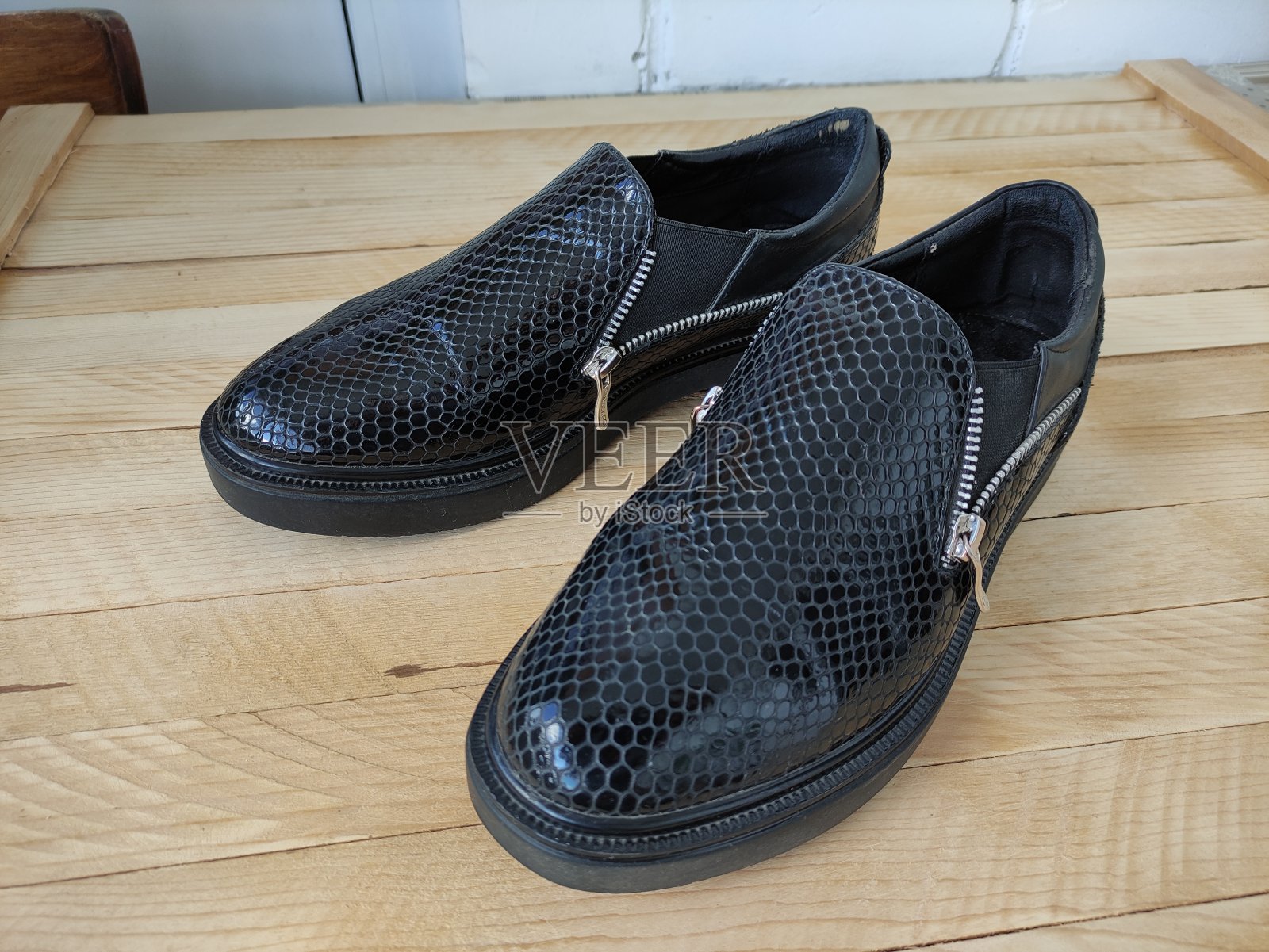 破旧的人造蛇皮女人鞋在木制背景照片摄影图片