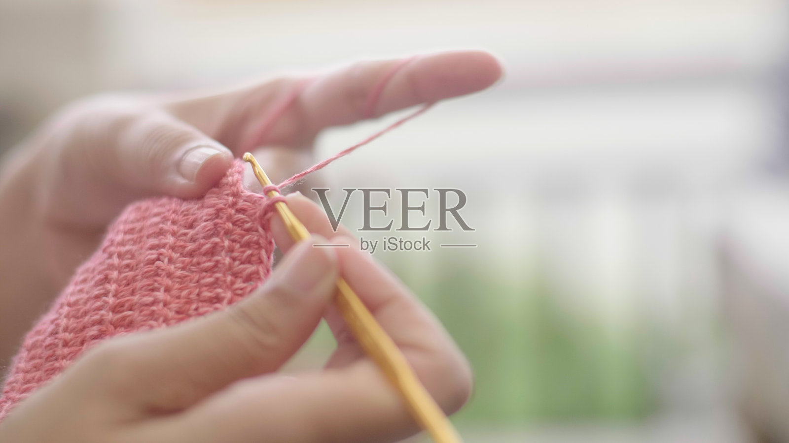 一个年轻女子手钩针的特写镜头。照片摄影图片