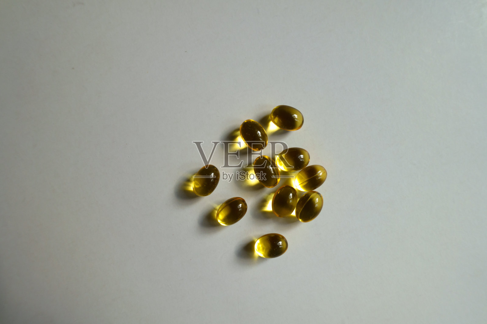 从上面取出少量维生素A(视黄醇棕榈酸酯)软胶囊照片摄影图片