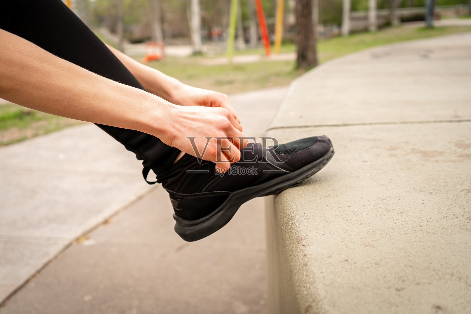 一名运动女子的肖像，系好鞋带，准备在公园慢跑。运动和健康生活方式的概念。照片摄影图片