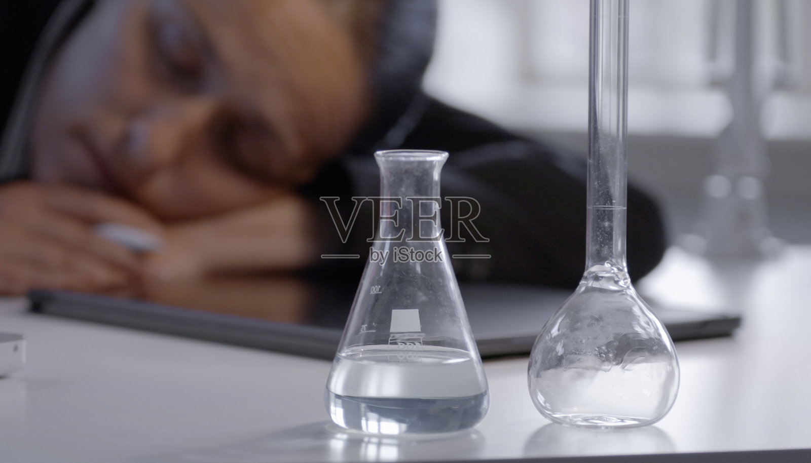 女科学家在桌子上睡觉，独自在办公室工作。照片摄影图片