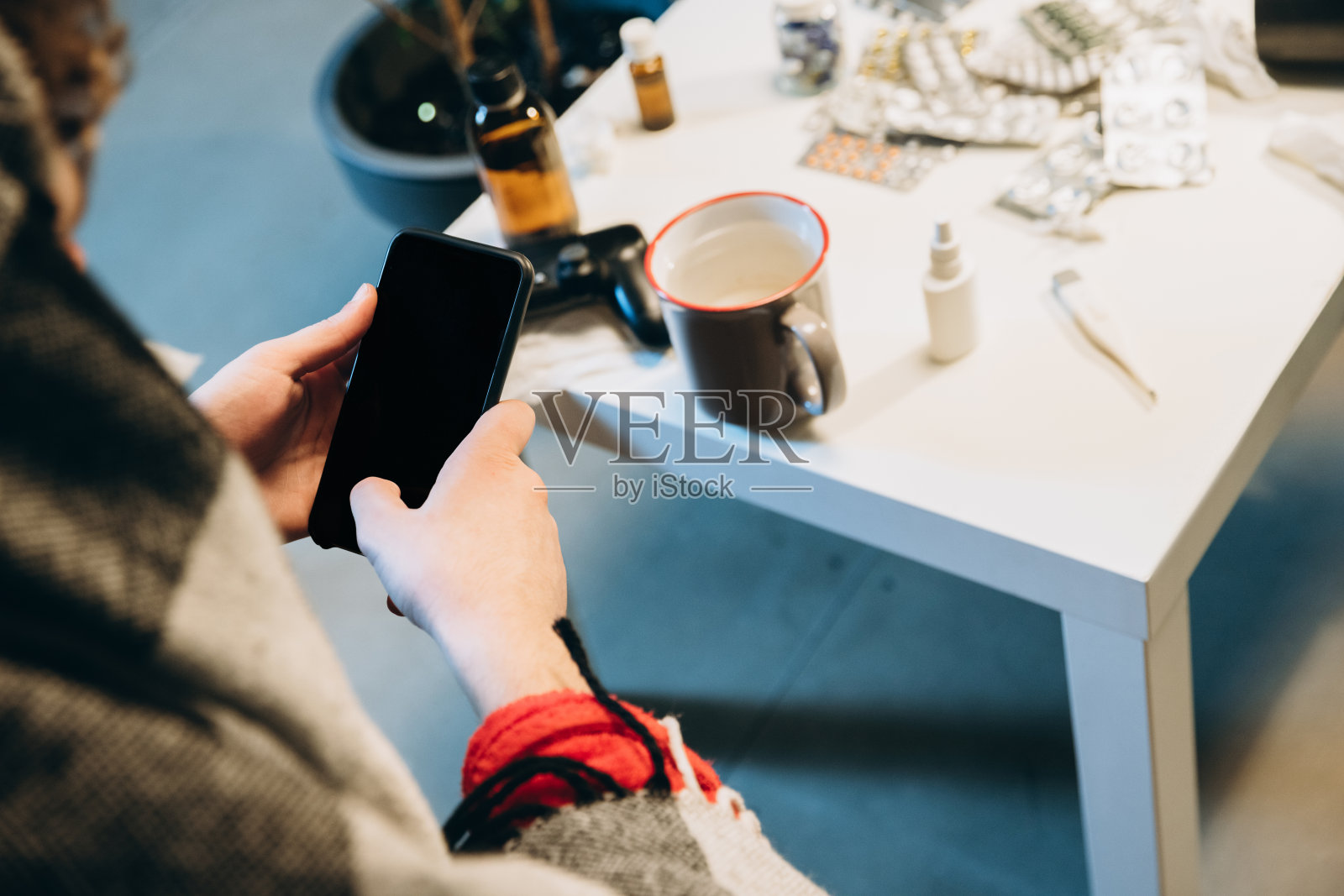 药品的图像，药片躺在桌子上，男孩拿着手机。在线咨询医生照片摄影图片