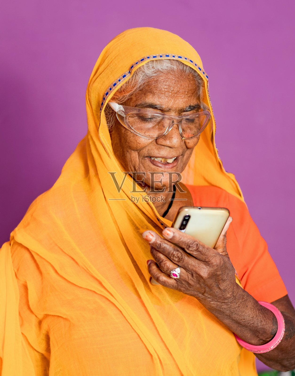 印度老祖母在用智能手机。照片摄影图片