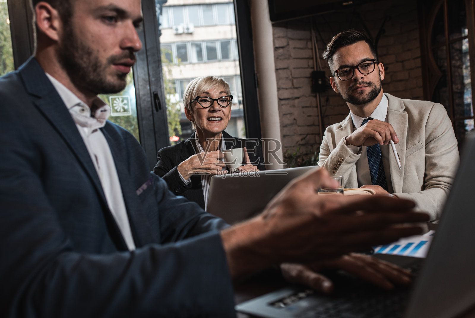商务人士在办公室自助餐厅开会讨论商业计划。照片摄影图片