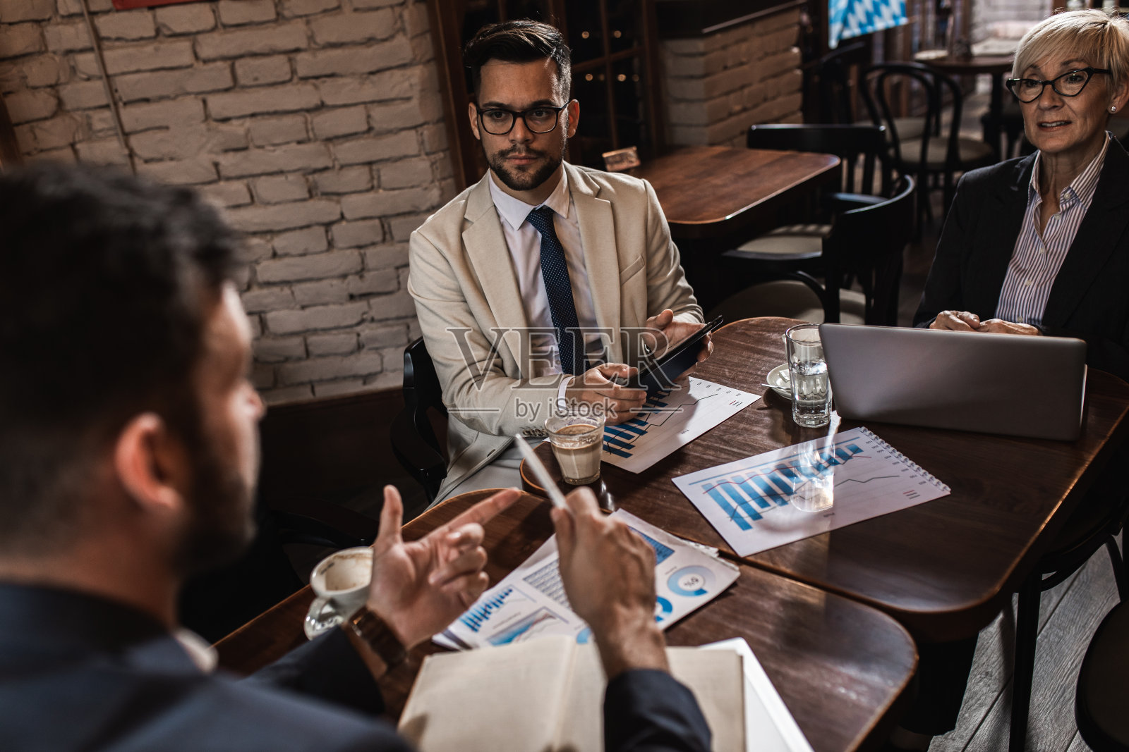 商务人士在办公室自助餐厅开会讨论商业计划。照片摄影图片