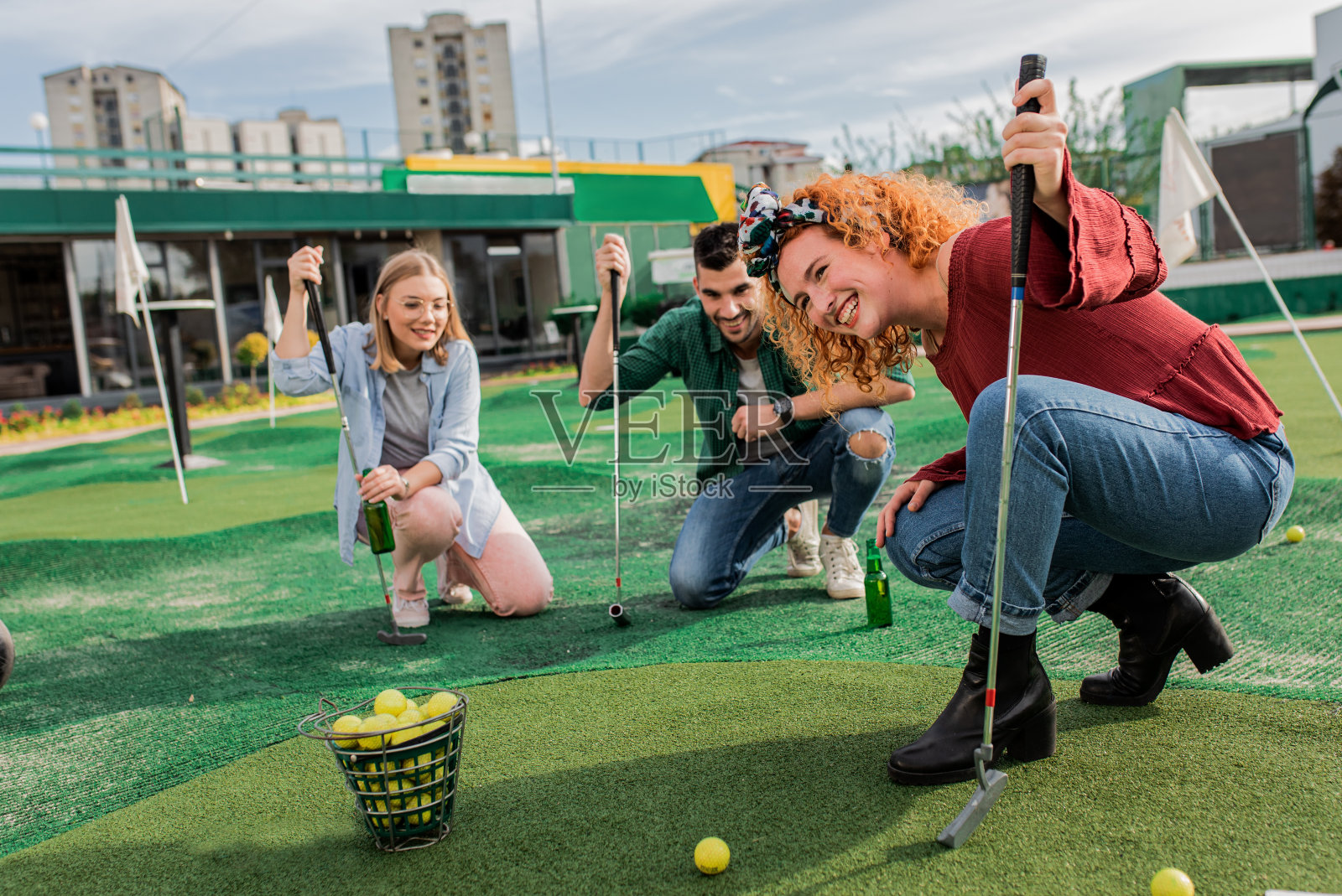 一群朋友在城市里一起玩迷你高尔夫。照片摄影图片