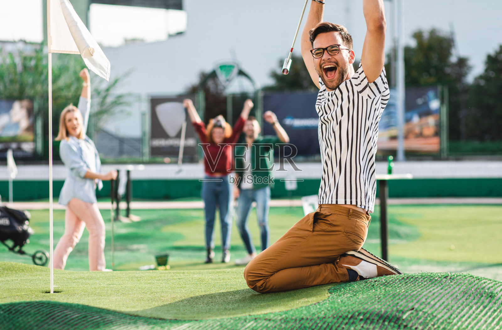 一群朋友在城市里一起玩迷你高尔夫。照片摄影图片