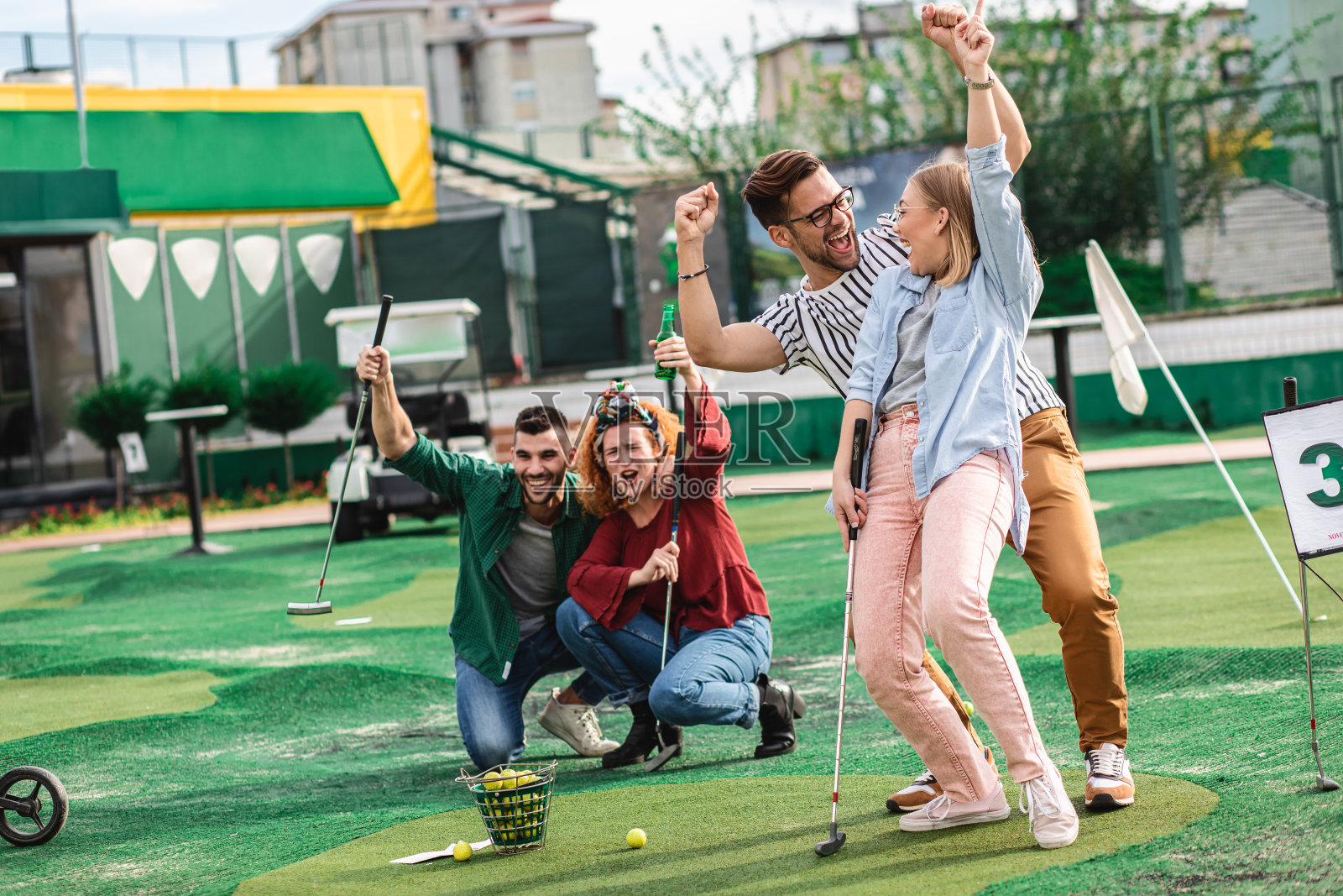 一群朋友在城市里一起玩迷你高尔夫。照片摄影图片