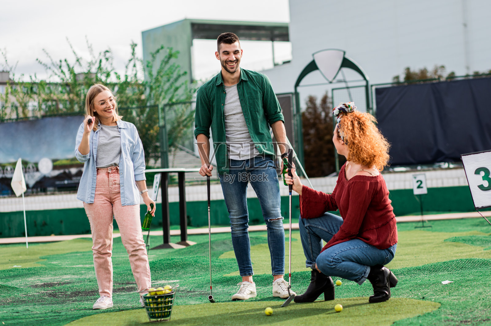一群朋友在城市里一起玩迷你高尔夫。照片摄影图片