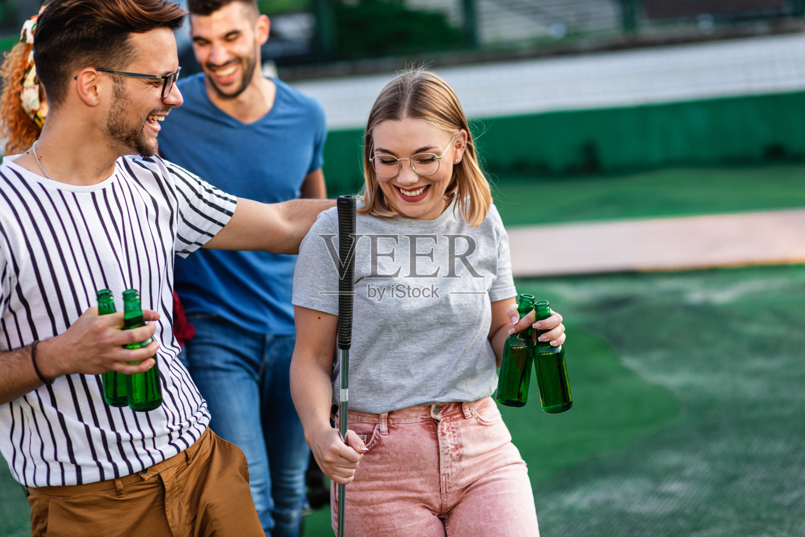 一群朋友在城市里一起玩迷你高尔夫。照片摄影图片