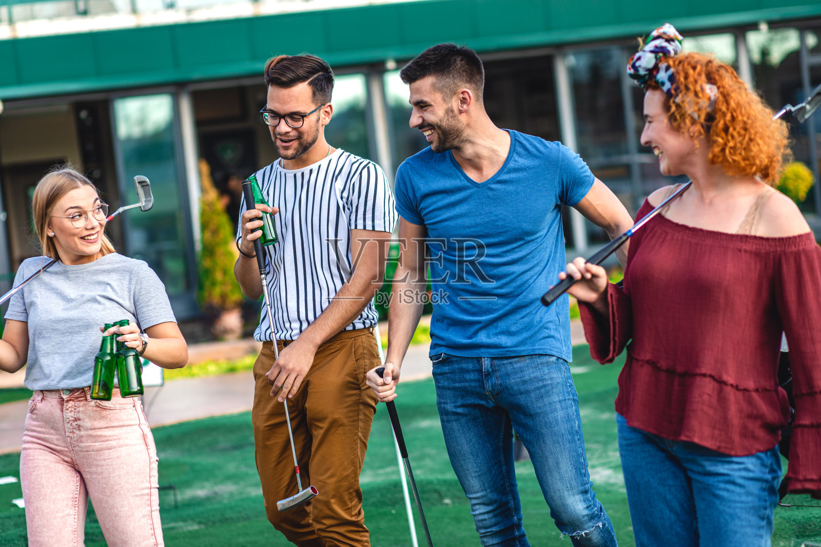 一群朋友在城市里一起玩迷你高尔夫。照片摄影图片