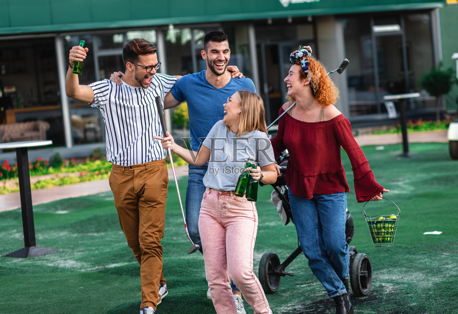 一群朋友在城市里一起玩迷你高尔夫。照片摄影图片