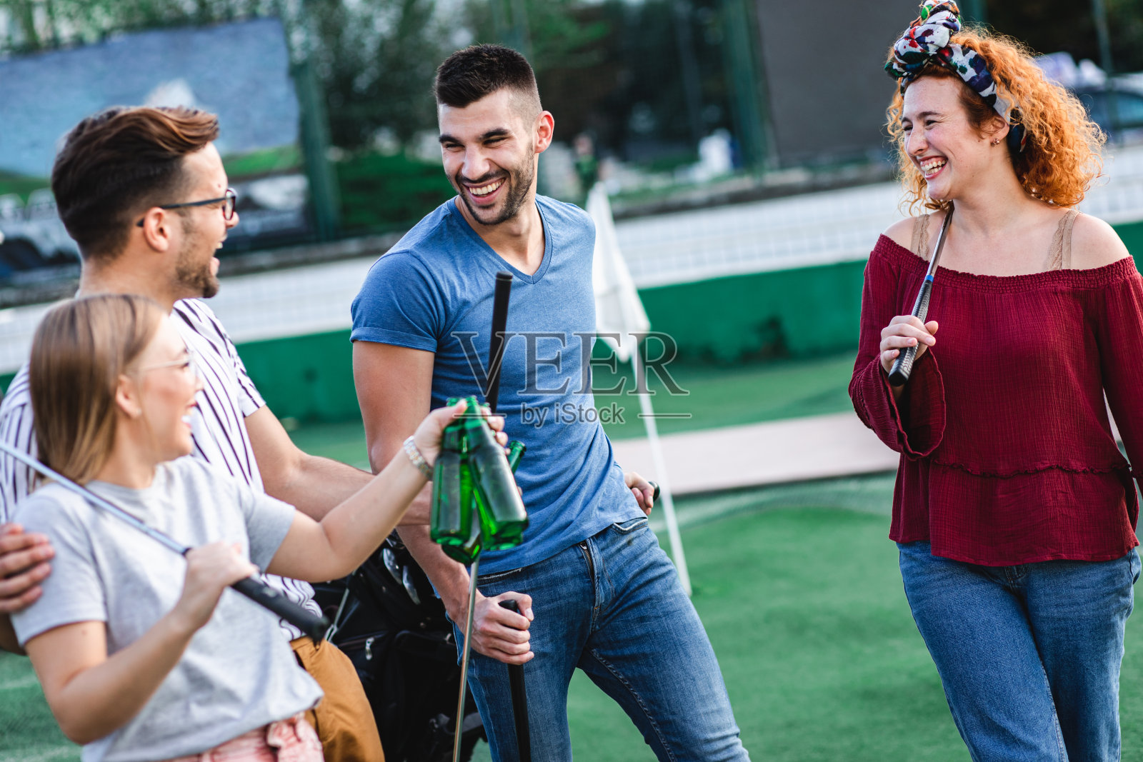 一群朋友在城市里一起玩迷你高尔夫。照片摄影图片
