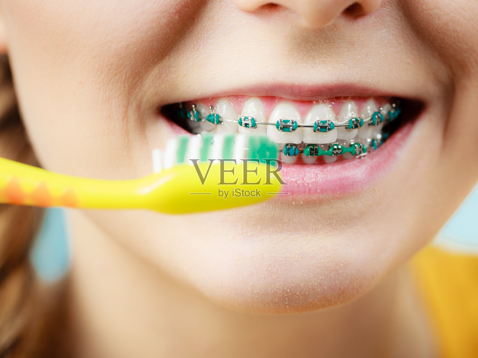 戴牙套的女人用牙刷照片摄影图片