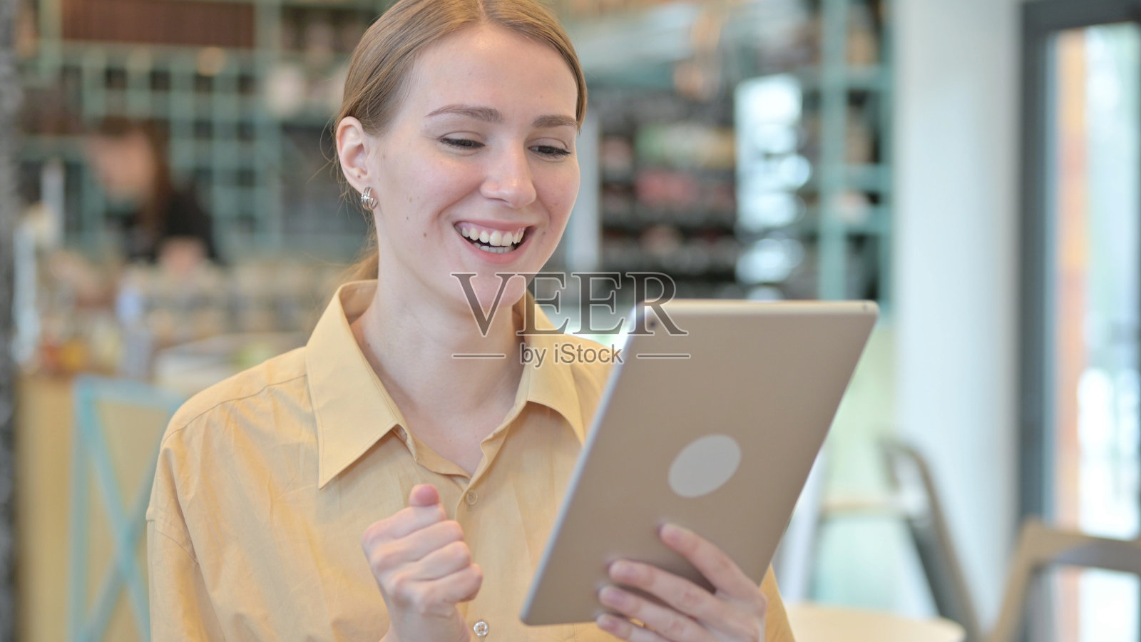 《庆祝在平板电脑上的成功》，作者:Young Woman照片摄影图片